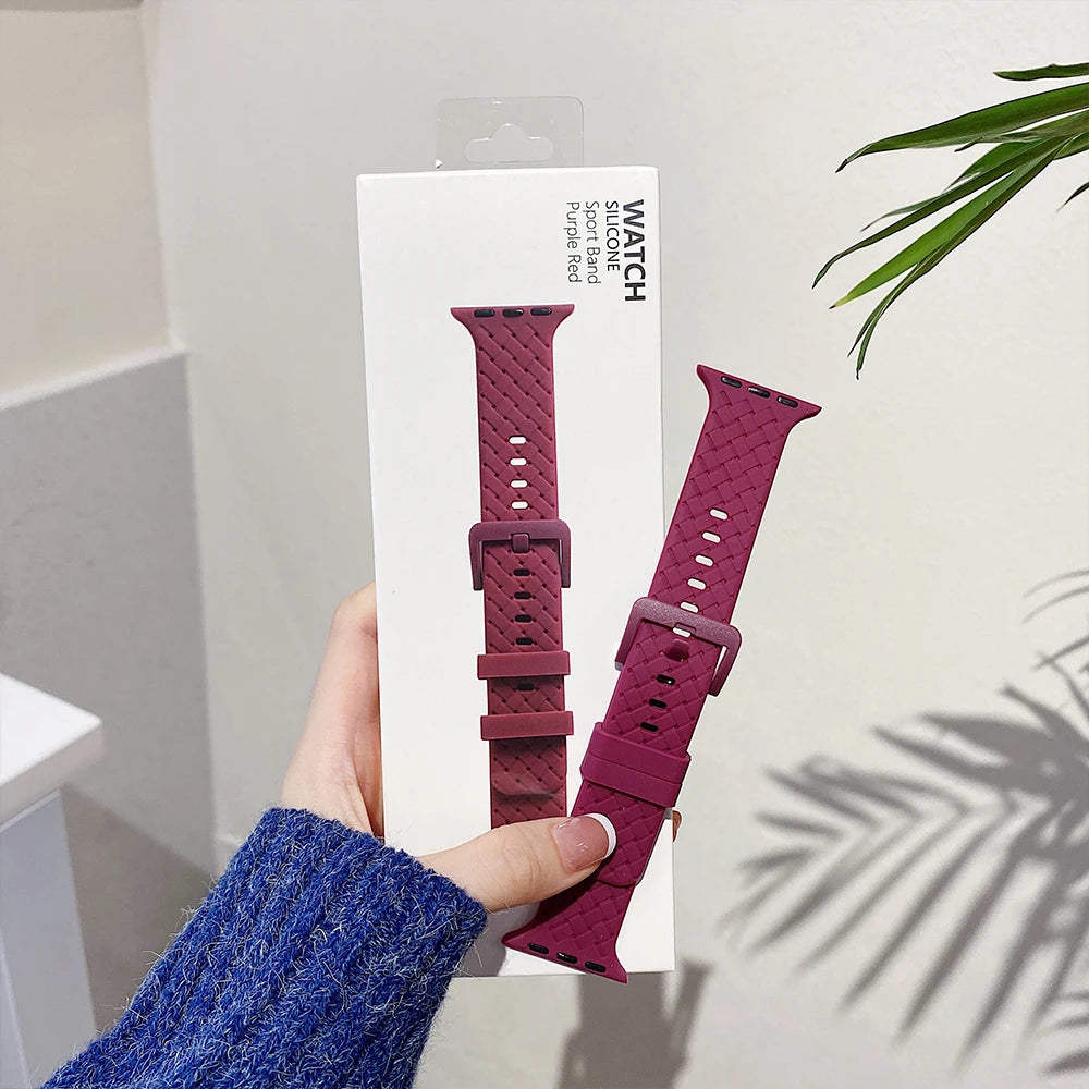 Burgundy basketweave strap beside its display card for Apple Watch