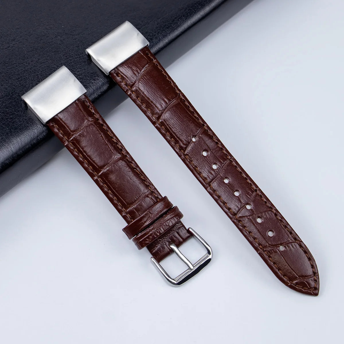 Garmin leather strap showing a premium brown replacement band for smartwatch, featuring crocodile texture and metal clasp.