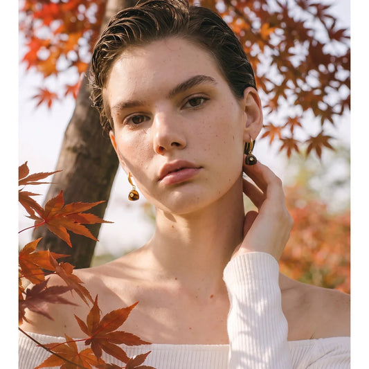 Woman wearing tiger's eye triangle drop earrings