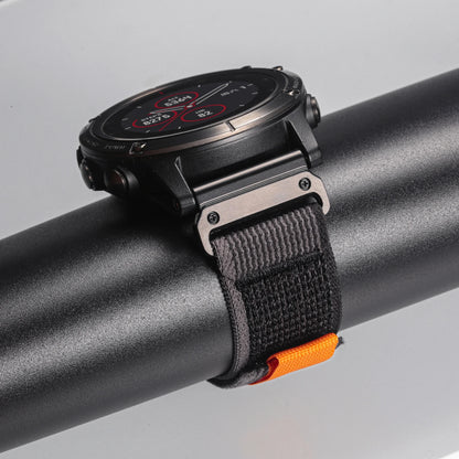 Garmin smartwatch with a rugged woven nylon sport band, showcasing durability and comfort on a sleek surface.