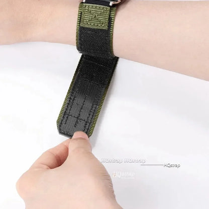 Adjustable Garmin nylon strap being secured on a wrist, showcasing its military style and durable design.