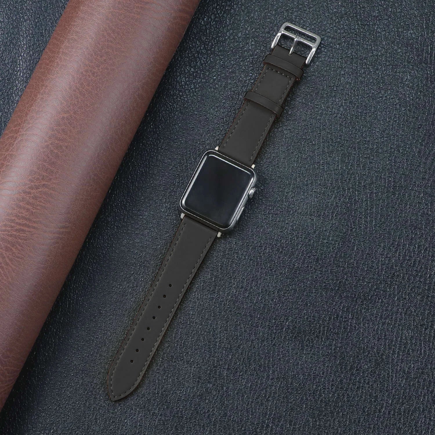 Apple Watch with a stylish brown fabric band, showcasing durability and comfort on a textured background.