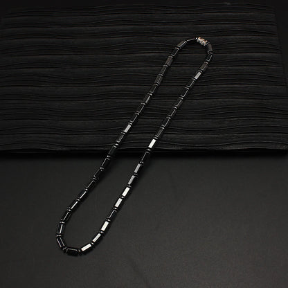 Simulated hematite bamboo bead necklace on a dark background