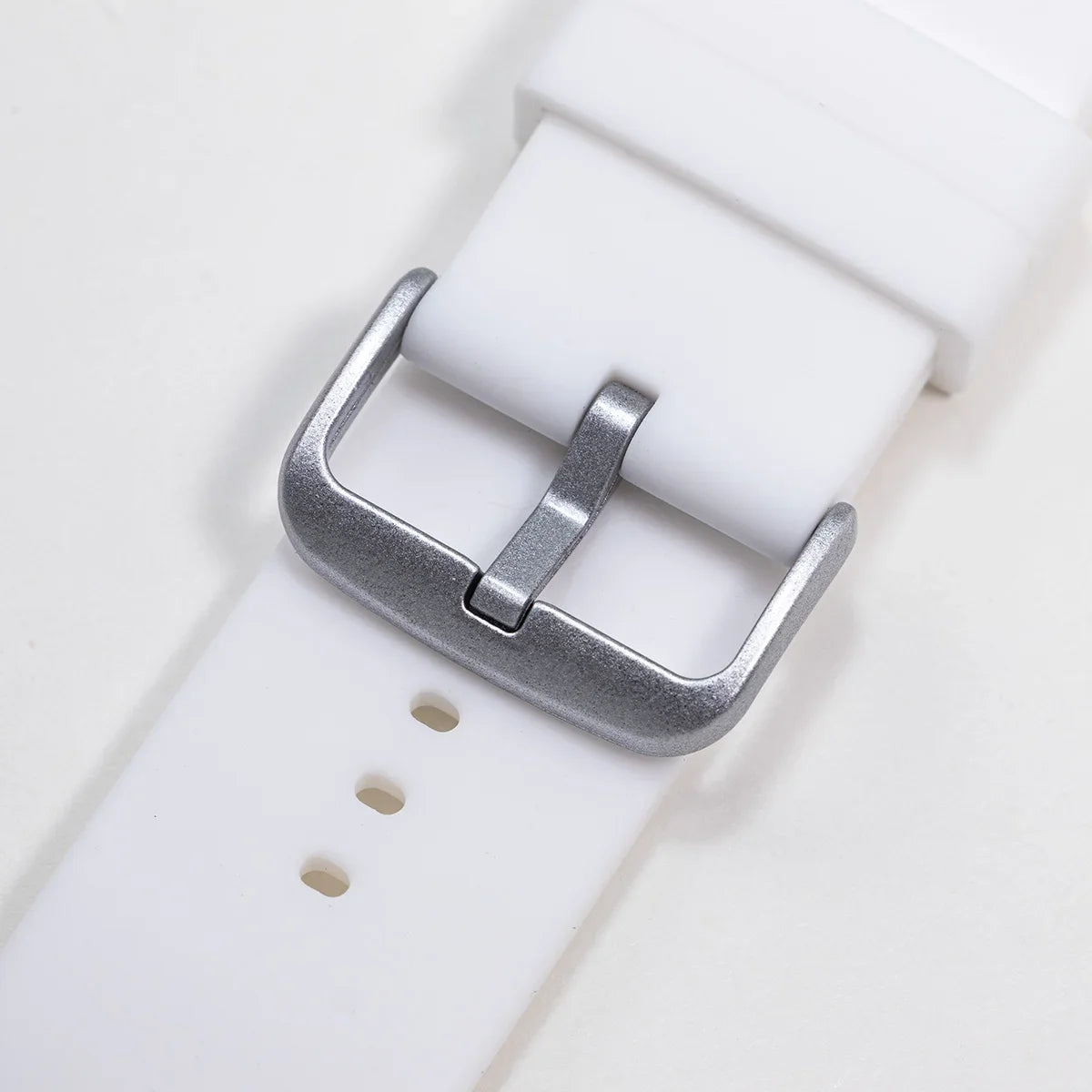 Garmin silicone watch strap close-up with silver metal buckle and multiple adjustment holes for a secure fit.