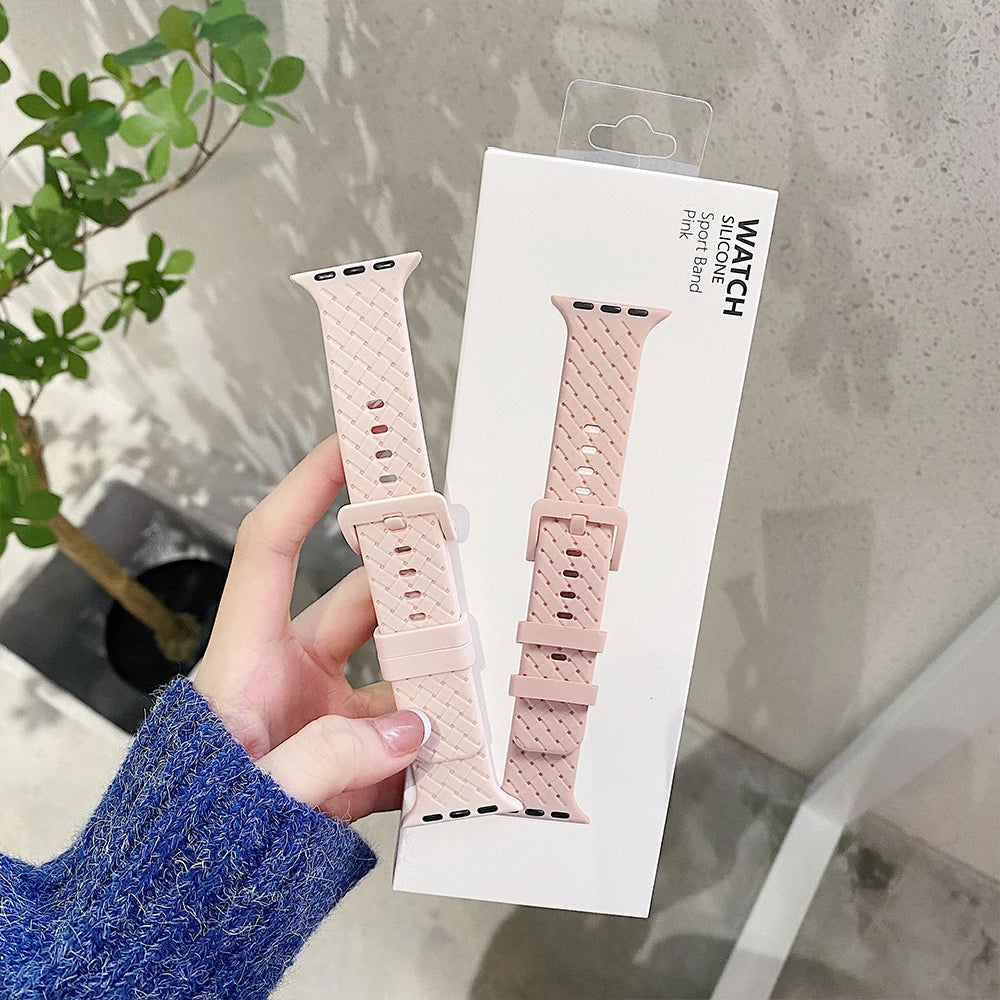 Flexible pink silicone strap for Apple Watch, showcased in packaging with a stylish design.