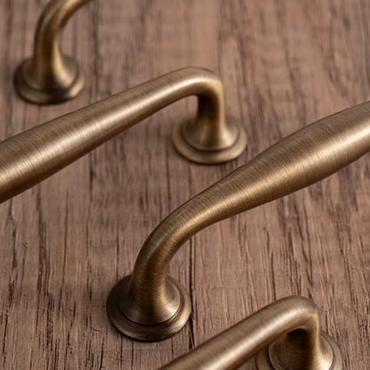 Arched solid brass cabinet pull in antique brass
