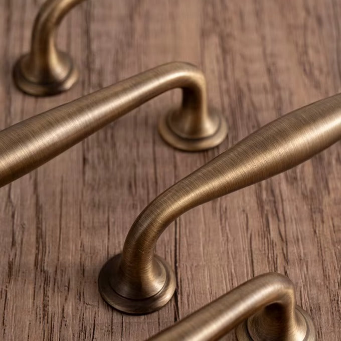 Arched solid brass cabinet pull in antique brass