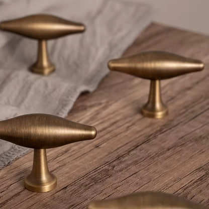 Arched olive-shaped solid brass T-bar cabinet knob in antique brass