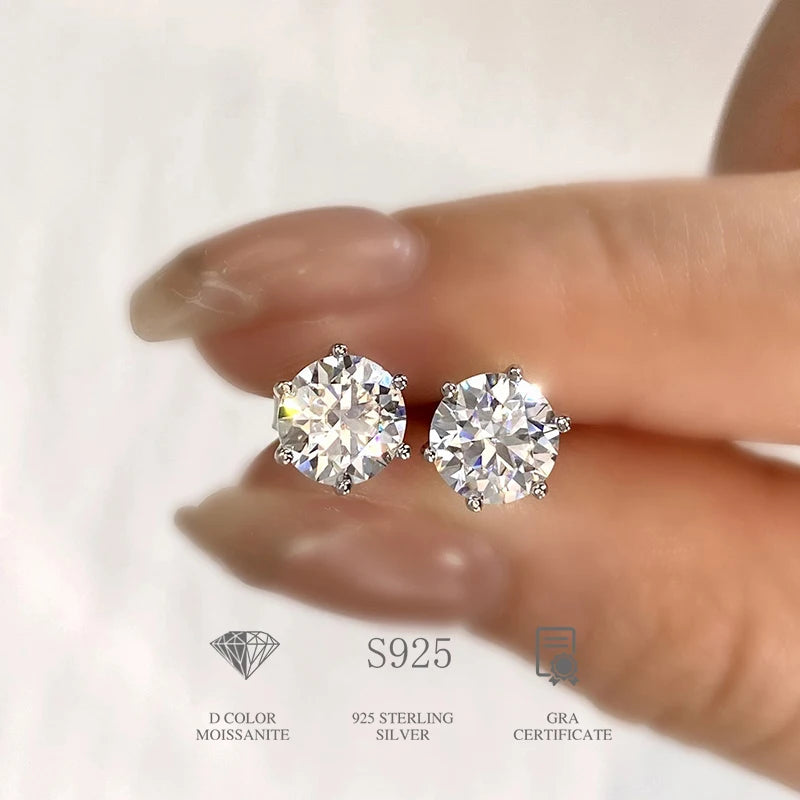 Six-Prong Moissanite Stud Earrings in Sterling Silver - silver pair held for scale