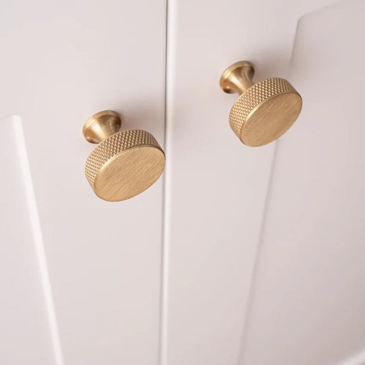 Knurled solid brass round cabinet knobs in brushed brass on cabinet doors