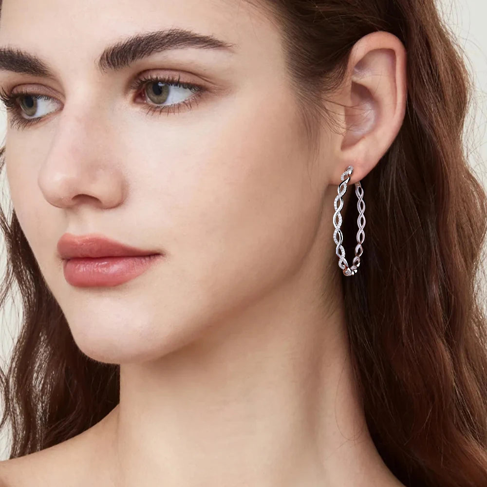 Twisted Infinity Moissanite Hoop Earrings in Sterling Silver — Twisted hoops worn on the ear