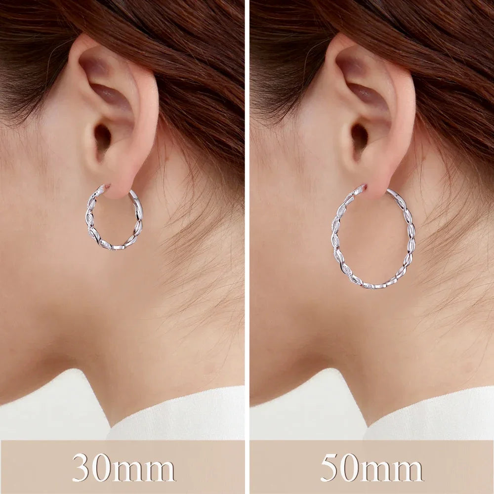 Twisted Infinity Moissanite Hoop Earrings in Sterling Silver — 30mm and 50mm hoops compared on the ear