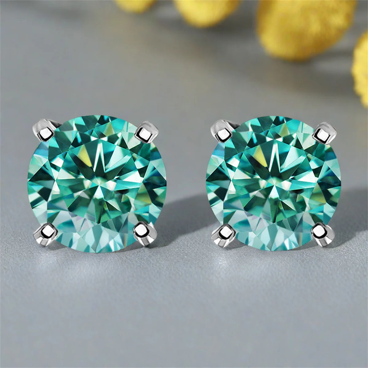 Cyan Round Moissanite Stud Earrings in Sterling Silver — Silver four-prong pair