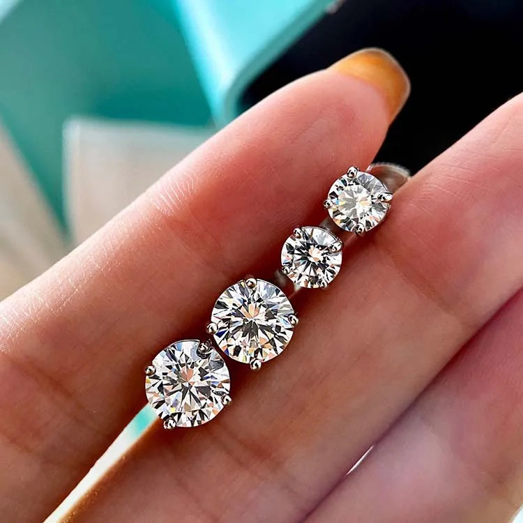 Four-Prong Round Moissanite Stud Earrings in Silver — Size comparison on hand